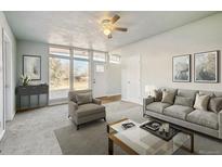Inviting living room with large windows, plush furnishings and neutral decor at 8280 E 104Th Way, Henderson, CO 80640