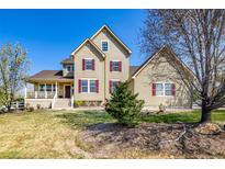 Charming two-story home with a well-maintained front yard, inviting porch, and red window shutters at 3225 Rinn Valley Dr, Longmont, CO 80504