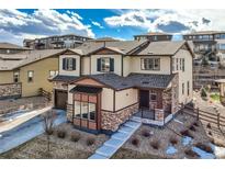 Beautiful two-story home with stone accents, a covered front porch, and well-maintained landscaping at 7897 S Jamestown Ct, Aurora, CO 80016