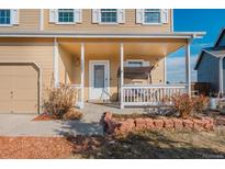 Charming front porch with swing seating, covered entrance, and attached two-car garage at 1387 Sunnyside St, Highlands Ranch, CO 80126