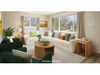 Bright living room featuring a neutral color palette, comfortable seating, and a large window at 740 Lotus Way, Broomfield, CO 80020