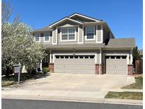 Charming two-story home featuring a well-manicured lawn, a three-car garage and beautiful mature landscaping at 15901 E 106Th Way, Commerce City, CO 80022