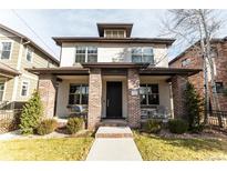 Charming two-story home with a brick-accented porch, inviting curb appeal, and well-maintained landscaping at 1152 S Ogden St, Denver, CO 80210