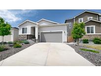 Charming single-story home featuring stone accents, a two-car garage, and meticulously landscaped front yard at 20 Vista Canyon Dr, Castle Rock, CO 80104
