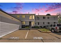 Two story home showcasing beautiful landscaping and a shared parking area at dusk at 5145 W 61St Dr # 14, Arvada, CO 80003