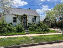 Charming single-Gathering home featuring overgrown landscaping and detached garage at 54 E Cornell Ave, Englewood, CO 80113
