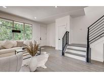Bright living room with a large window, modern staircase, and neutral-toned decor, creating an inviting atmosphere at 536 Cook St, Denver, CO 80206