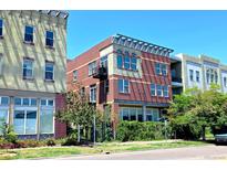Attractive three-story brick building with modern architectural details and lush greenery at 1521 Central St # 2D, Denver, CO 80211