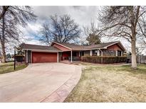 Charming brick single-Gathering home with a well-manicured lawn, a two-car garage, and a welcoming front porch at 3820 S Ames St, Denver, CO 80235