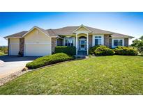 Charming home featuring a manicured lawn, mature landscaping, and a welcoming facade at 34942 Wagon Wheel Trl, Elizabeth, CO 80107