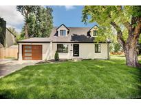 Charming home with a well-manicured lawn, classic white exterior, and a modern garage door at 1980 S Kearney Way, Denver, CO 80224