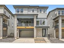 Beautiful three-story home featuring stone accents, a two-car garage, and an inviting covered porch at 3127 S Russell St, Morrison, CO 80465