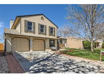Charming two-story home with a two-car garage and manicured front lawn on a sunny day at 2023 S Rifle St, Aurora, CO 80013