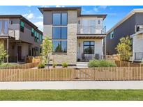 Charming two-story home with a mix of stone and siding and a cozy front porch and gated front yard at 21405 E 59Th Dr, Aurora, CO 80019