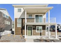 Two-story home with a charming balcony, green door, and neutral-tone siding at 17717 E 54Th Ave, Denver, CO 80249