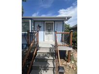 A charming entryway with wooden steps and railing leads to the front door of this home at 3306 S Logan St, Englewood, CO 80113
