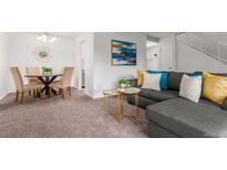Bright living room with gray sectional sofa and dining area at 7995 E Mississippi Ave # G5, Denver, CO 80247