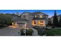 Charming two-story gray home with a well-manicured front yard, covered porch, and attached two-car garage at 9375 S Hoyt Ct, Littleton, CO 80127
