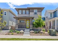 Charming two-story home with a modern exterior, landscaped yard, and a welcoming yellow front door at 21482 E 60Th Ave, Aurora, CO 80019