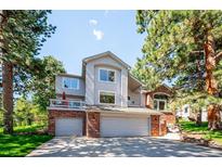 Charming two-story home with a well-maintained lawn, mature trees, and a two-car garage at 2397 Hearth Dr, Evergreen, CO 80439