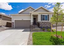 Charming single-story home with stone accents, landscaped front yard, and attached two-car garage at 19100 E 96Th Pl, Commerce City, CO 80022