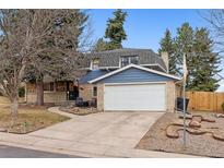 Charming brick and blue two-story home featuring an attached two-car garage and landscaped front yard at 8785 E Floyd Cir, Denver, CO 80231