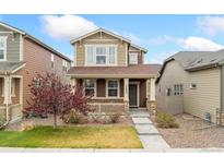 Charming two-story home featuring a cozy front porch and well-maintained landscaping at 15842 E Warner Dr, Denver, CO 80239