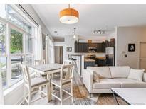 Bright living room with a dining table, modern furnishings, and large windows for natural light at 5677 S Park Pl # A102, Englewood, CO 80111