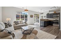 Bright open-concept living room features large windows, hardwood floors, and modern finishes at 5677 S Park Pl # A102, Englewood, CO 80111