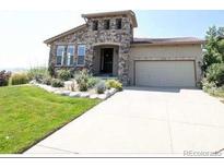 Charming two-story home with a stone facade, two car garage, and well-manicured front yard at 2373 S Joyce St, Denver, CO 80228