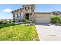 Charming stone accented two-story home with well-maintained lawn and attached two-car garage at 2373 S Joyce St, Denver, CO 80228