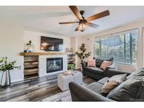 Inviting living room with a fireplace, ceiling fan, and plush seating, perfect for relaxation and entertaining at 16685 Trail Sky Cir, Parker, CO 80134