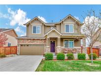 Charming two-story home with stone accents, manicured lawn and a two car garage in a residential neighborhood at 471 N Jackson Gap Way, Aurora, CO 80018