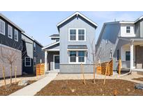 Charming gray two-story home with landscaped front yard, featuring a modern architectural style at 3325 N Coolidge Way, Aurora, CO 80019