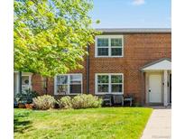 Brick townhome featuring a well-maintained lawn, mature trees and updated windows at 2872 Jasmine St, Denver, CO 80207