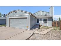 Charming home featuring a two-car garage and inviting entryway, perfect for a cozy Gathering living at 1923 Ensenada Ct, Aurora, CO 80011