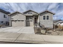 Two-story house with gray siding, stone accents, and a two-car garage at 2905 Morningbird Ln, Castle Rock, CO 80109