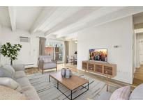 Bright living room featuring wood floors, white ceiling beams, and comfortable furniture at 100 S Clarkson St # 304, Denver, CO 80209