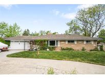 Charming ranch-style home with a well-manicured lawn, a covered porch, and an attached garage at 9045 W Ithaca Pl, Denver, CO 80235