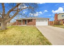 Charming brick ranch home with a well-maintained lawn and mature tree at 13424 Virgo Dr, Lone Tree, CO 80124