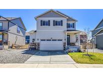 Charming two-story home with a two-car garage, stone accents and well-maintained landscaping at 45840 Laceleaf Dr, Bennett, CO 80102
