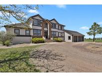 Stately two-story home featuring a three-car garage and attractive architectural details at 897 E Rim Rd, Franktown, CO 80116
