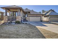 Charming single-Gathering home with a stone facade, covered porch, and well-manicured lawn at 23960 E Easter Pl, Aurora, CO 80016