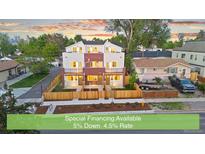 Newly constructed townhomes featuring a charming brick and siding exterior with fenced front yards at 1048 Knox Ct, Denver, CO 80204