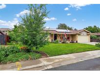 Charming ranch home featuring solar panels, a well-maintained lawn, and lovely landscaping at 11835 W 37Th Pl, Wheat Ridge, CO 80033