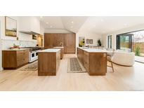 Bright, open kitchen with double islands, marble countertops, stainless appliances, and custom wood cabinets at 3235 S Saint Paul St, Denver, CO 80210