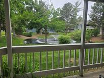 Scenic pond view from the porch, featuring a fountain and lush greenery at 8600 E Alameda Ave # 105, Denver, CO 80247