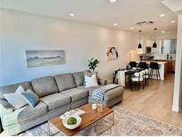 Open living room features stylish sectional sofa and flows into dining area at 5128 W 26Th Ave # 208, Denver, CO 80212