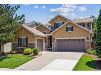 Charming two-story home featuring a well-manicured lawn and an attached two-car garage at 3102 Fox Sedge Pl, Highlands Ranch, CO 80126