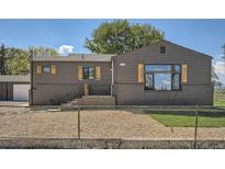 Charming home with a modern exterior, featuring dark siding, brick accents, and well-kept landscaping at 5555 Julian St, Denver, CO 80221